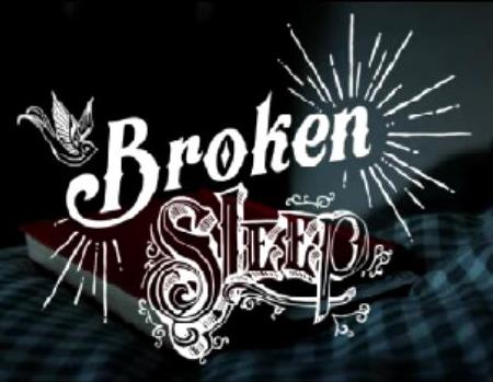 Title card from Broken Sleep in a decorative font, superimposed over a red book on a checkered bedspread.