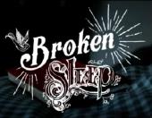 Title card from Broken Sleep in a decorative font, superimposed over a red book
                on a checkered bedspread.