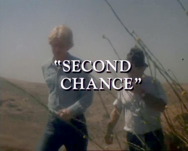 Ed Begley, Jr., (as Frank) and Orin Cannon (as the old farmer) hike determinedly through a dry field.